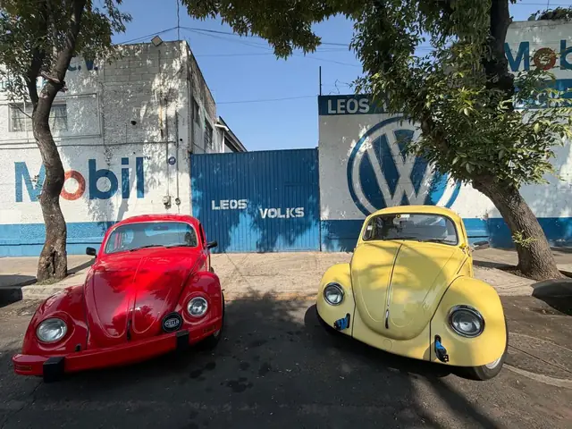 Vocho rojo y vocho amarillo frente al portón de Leos Volks