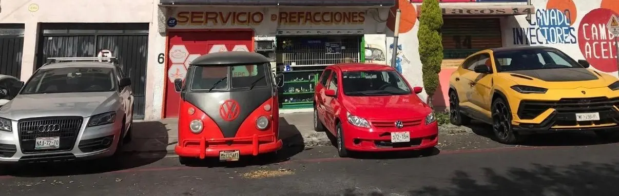 Audi, combi Volkswagen, Golf y Lamborghini Urus estacionados frente al taller Leos Volks